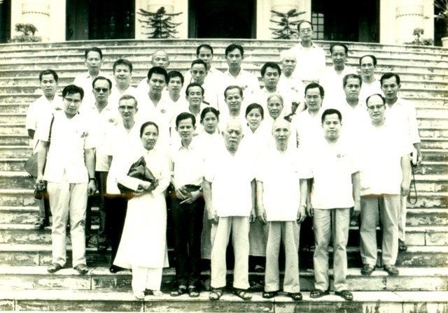 Các đại biểu Việt kiều chụp ảnh kỷ niệm với Bác Tôn Đức Thắng, Bác Nguyễn Lương Bằng. (Hàng 1: Bà Hồ Đác Chi, Lâm Bá Châu. Nguyễn Ngọc Hà; Hàng 2: Ngyễn Ngọc Giao, Nguyễn Ngọc Yến, Phạm Nguyệt Yến; Hàng 3: X, Nguyễn Ngọc Trân, Võ Gia Phục Quốc, Võ Thành Nghĩa, Nguyễn Vĩnh Mỹ, Ngô Hải Thái, Đoàn Thu Phong; Hàng 4: Phùng Công Khải, Trần Thi, Lê Huy Cận, Hàng 5: Phạm Văn Ký, Nguyễn Đức Linh, Phạm Đồng, Nguyễn Văn Bổn; Hàng 6: Y, Trần Thanh Xuân, Cụ Mạc, Lê Thành Khôi. Không có trong ảnh Dương Minh Đức).
