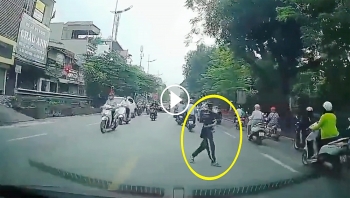 Cậu bé vòng tay, cúi đầu cảm ơn khi được tài xế nhường đường