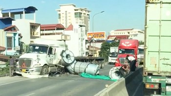 Bị container tạt đầu, xe đầu kéo rơi hàng loạt cuộn tôn xuống đường