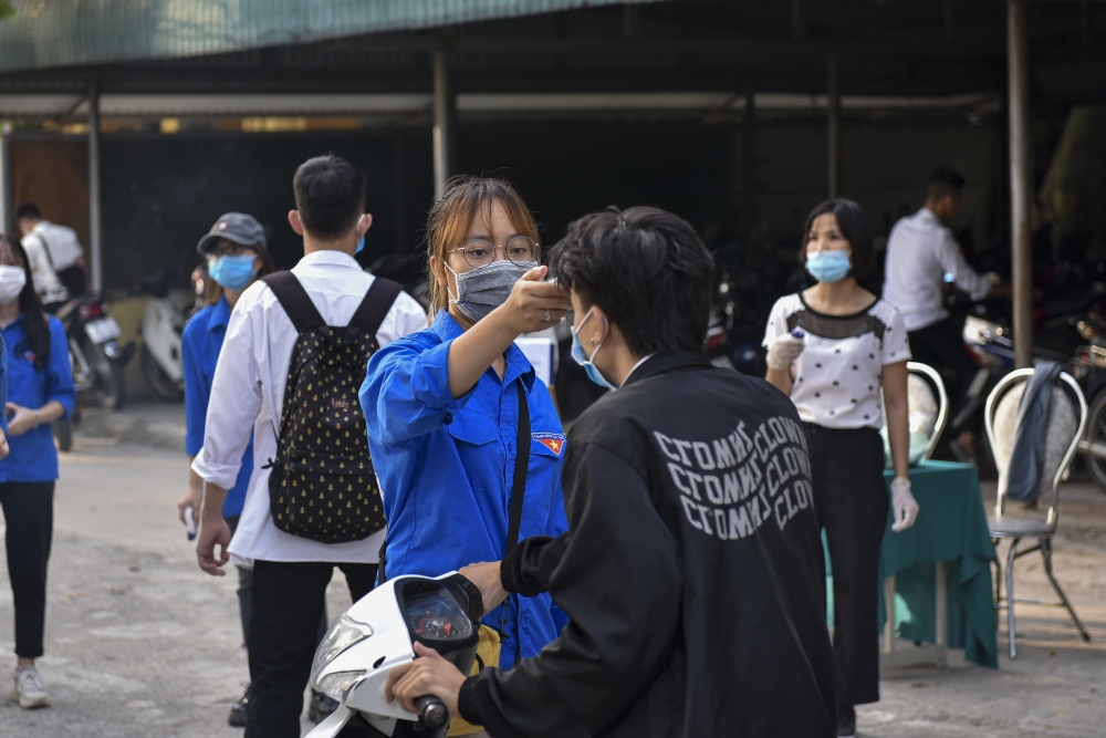 Ảnh: Thí sinh được kiểm tra y tế trước khi bước vào phòng thi tốt nghiệp THPT 2020 sáng 9/8/2020