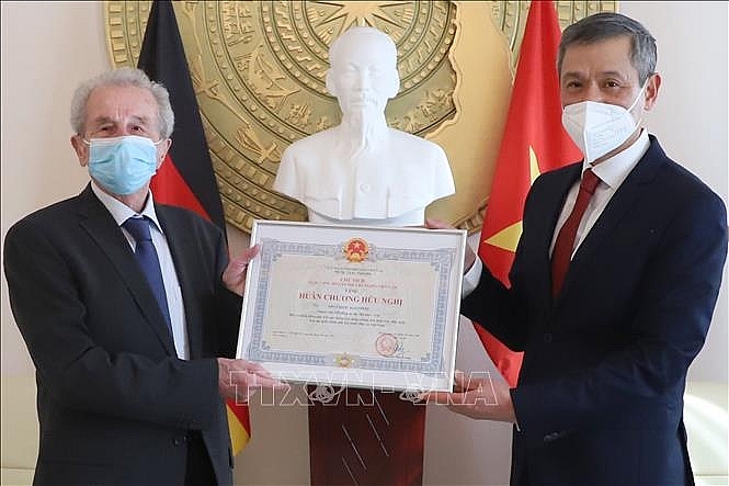 Đại sứ Nguyễn Minh Vũ (phải) trao Huân chương Hữu nghị cho ông Siegfried Kaulfuss.