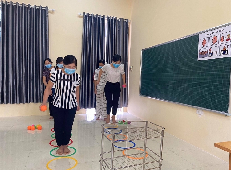 Giáo viên thực hành sử dụng đồ chơi vận động cho trẻ khuyết tật.