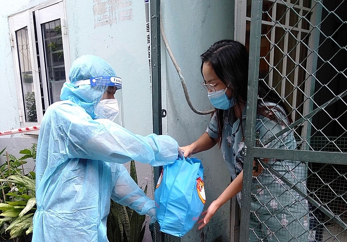 Người dân khó khăn trên địa bàn quận 12, TP HCM nhận phần quà hỗ trợ từ cán bộ MTTQ. 
