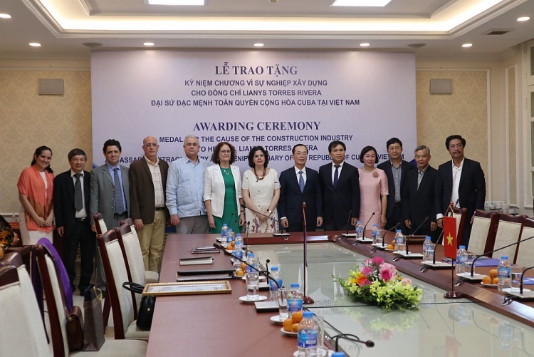 Bộ trưởng Phạm Hồng Hà chụp ảnh lưu niệm cùng bà Lyanis Torres Rivera và các đại biểu tham dự buổi lễ