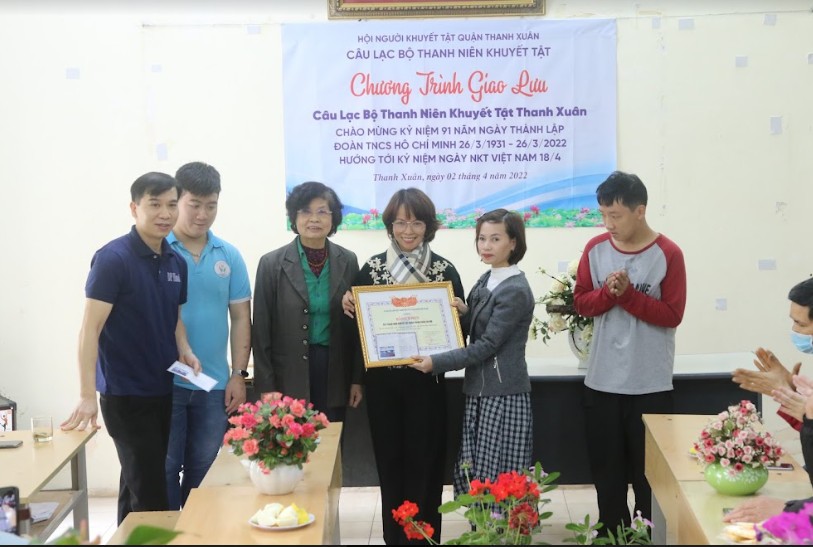 Thay mặt Câu lạc bộ Thanh niên khuyết tật quận Thanh Xuân, chị Phạm Thu Trang (người quàng khăn) nhận bằng khen của Ủy ban Hội liên hiệp thanh niên Việt Nam thành phố Hà Nội. Ảnh: NVCC