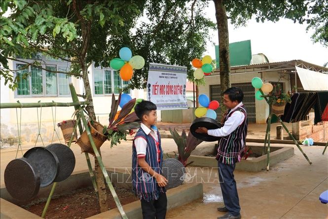 Học sinh được trải nghiệm tập đánh chiêng tại tiết học. Ảnh: TTXVN