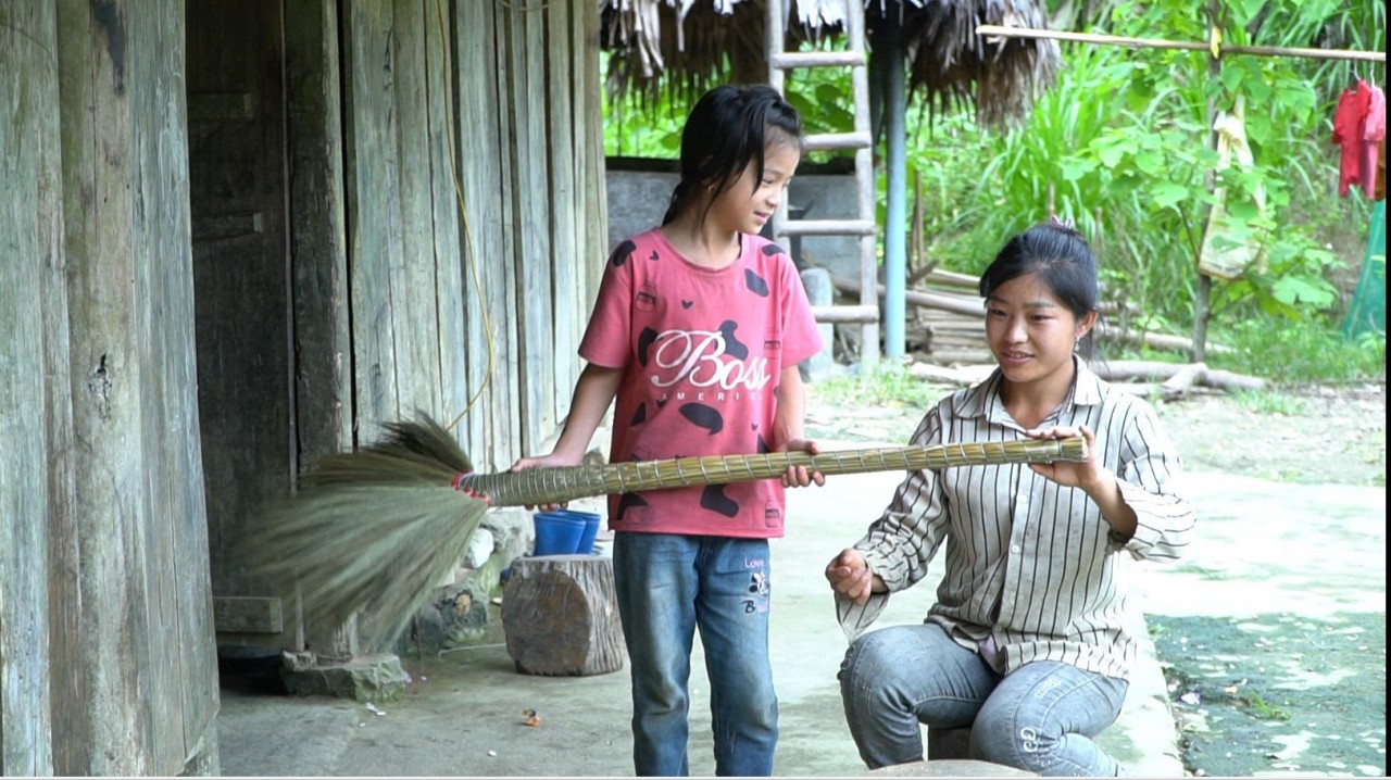 Bích hỗ trợ mẹ làm chổi. Ảnh: Thực phẩm Mường Pa