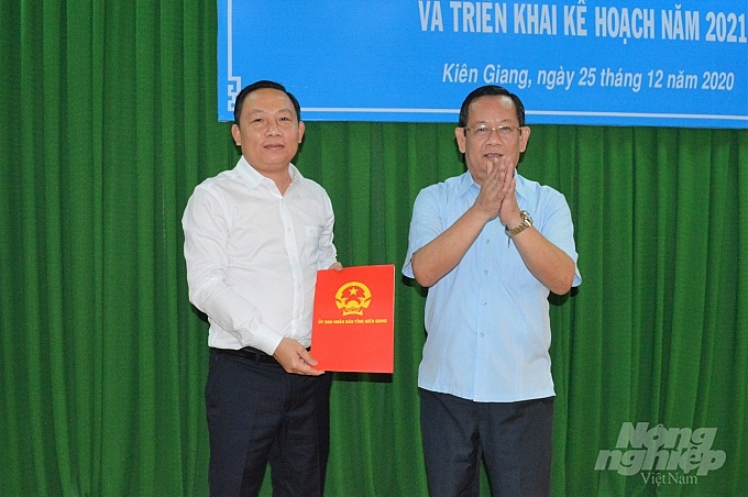Ông Nguyễn Hoàng Thông, Giám đốc Sở Nội vụ Kiên Giang trao quyết định của Chủ tịch UBND tỉnh cho ông Lê Hữu Toàn (Ảnh: Báo Nông nghiệp)