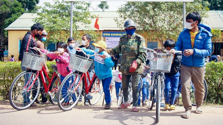 Phụ huynh và các em học sinh sau buổi lễ tại trường Tiểu học Thuận, phấn khởi mang xe đạp về nhà