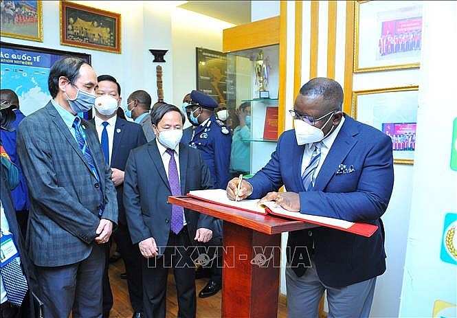 Tổng thống Julius Maada Bio viết lưu bút tại phòng truyền thống Viện Khoa học Nông nghiệp Việt Nam. Ảnh: Minh Đức/TTXVN