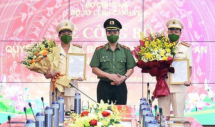 Thiếu tướng Trần Hải Quân (giữa) trao quyết định cho 2 cán bộ