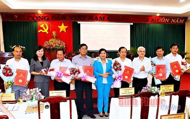 Ông Nguyễn Tấn Hùng (bìa trái) và ông Nguyễn Quốc Dũng (bìa phải) nhận Quyết định bổ nhiệm (Ảnh: Báo Bình Phước)