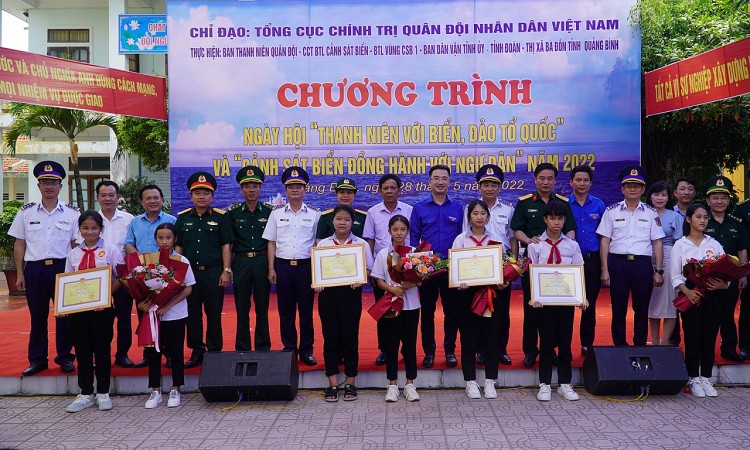 Đại biểu tham dự chương trình chụp ảnh lưu niệm cùng các em học sinh đạt giải trong cuộc thi “Em yêu biển, đảo quê hương”. Ảnh: Báo Quảng Bình